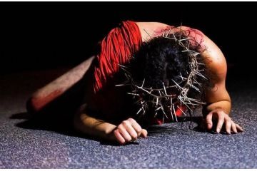 Nella scena della rappresentazione, Cristo è raffigurato a terra, privo di indumenti, con una sola mantella rossa che lo avvolge. La sua testa è coronata da spine, simbolo della sofferenza e dell'umiliazione che sta vivendo. Il corpo, segnato da lividi e ferite, racconta la brutalità della sua passione.