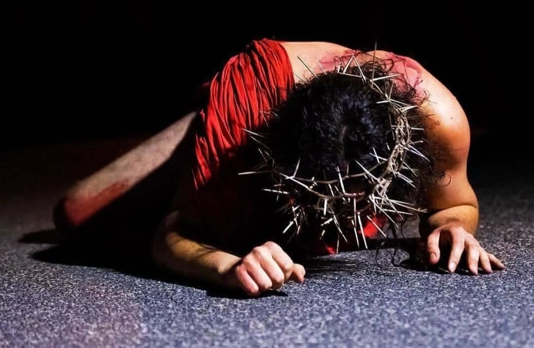 Nella scena della rappresentazione, Cristo è raffigurato a terra, privo di indumenti, con una sola mantella rossa che lo avvolge. La sua testa è coronata da spine, simbolo della sofferenza e dell'umiliazione che sta vivendo. Il corpo, segnato da lividi e ferite, racconta la brutalità della sua passione.