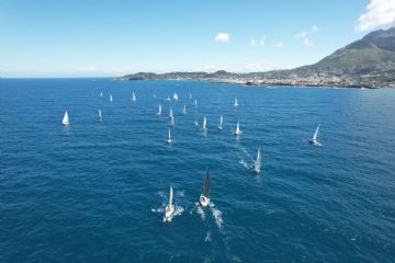 Una panoramica suggestiva delle vele che partecipano alla regata di 24 ore, con l'isola visibile in lontananza