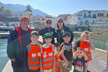 Foto di gruppo vicino al Porto di Forio, con i partecipanti sorridenti e soddisfatti del loro lavoro di pulizia della spiaggia. Il mare e il porto fanno da sfondo, testimoniando l’impegno per un ambiente più pulito e sostenibile.