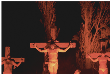 La foto mostra il Cristo in Croce durante la Via Crucis a Panza, con un'atmosfera di preghiera e riflessione, dove il volto di Gesù esprime sofferenza e spiritualità.