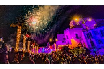 Scena natalizia con lo sfondo del paesaggio di Forio illuminato da fuochi d’artificio.