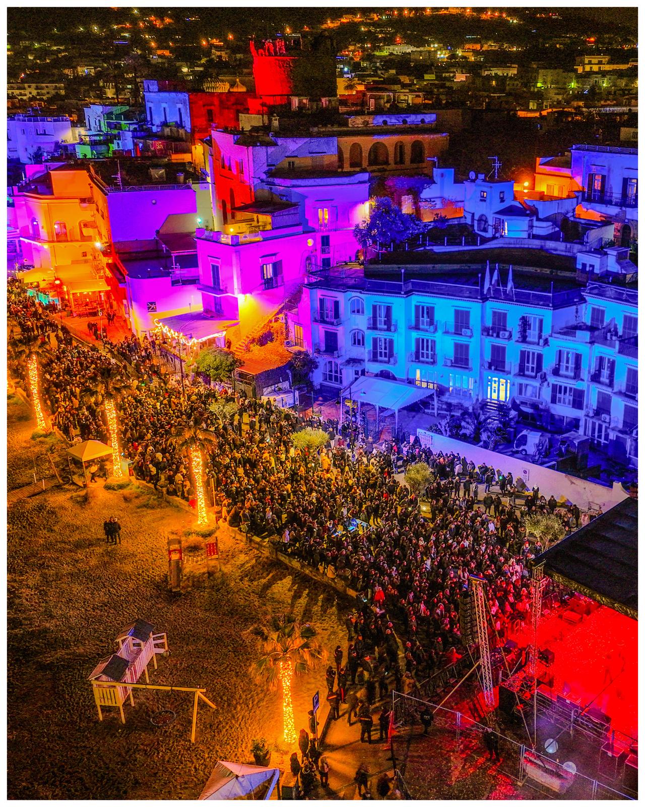 Suggestivo scorcio aereo di Forio, con la città illuminata dalle atmosfere natalizie e il concerto di Natale in corso.