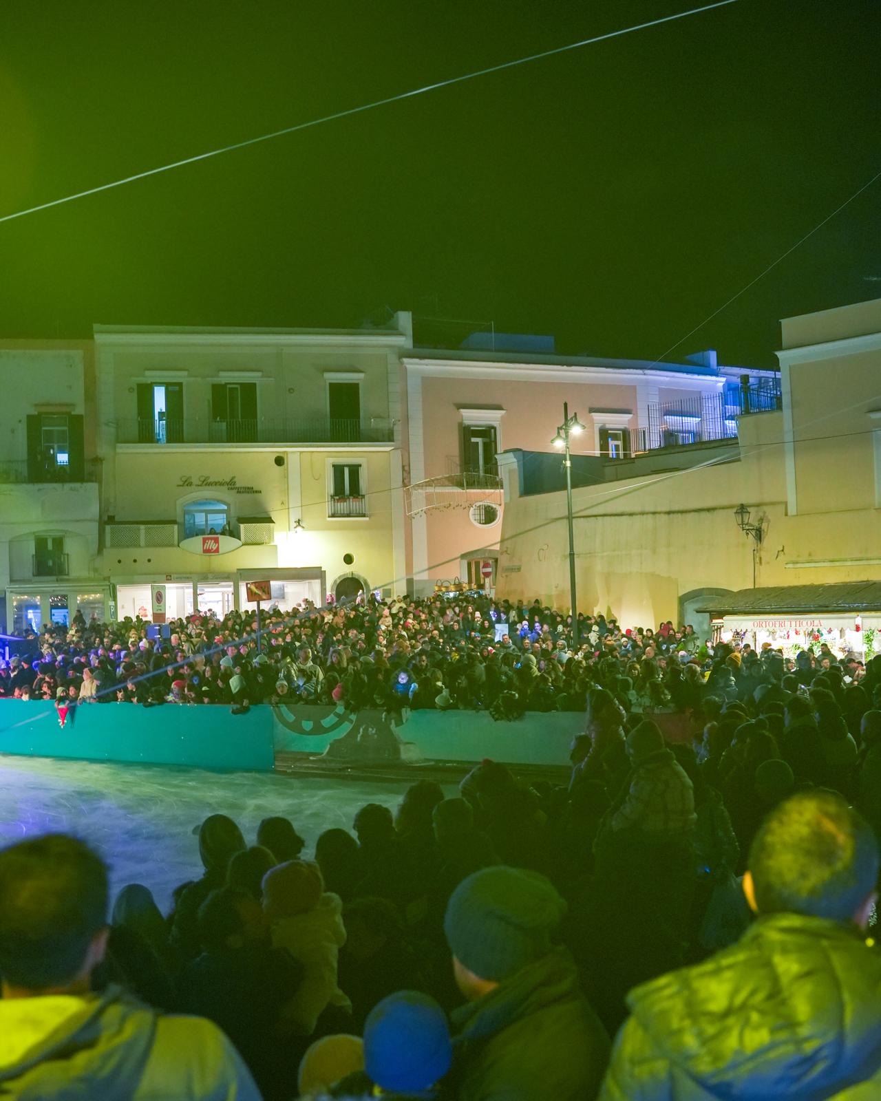 La pista di ghiaccio animata da numerosi visitatori durante lo spettacolo di intrattenimento natalizio.